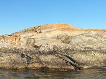 Scenic view of rocks against clear blue sky