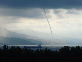 View of tornado in lake against sky