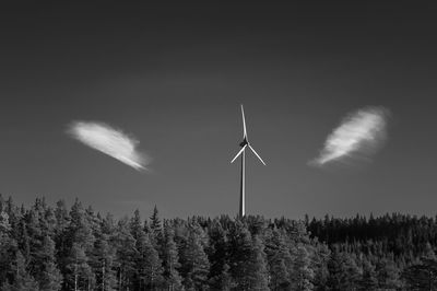 Windmill and trees against sky