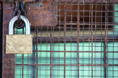 Close-up of padlock on rusty metal door