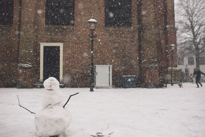 Snowman on field against building