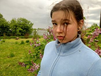 Close-up of girl on field against sky