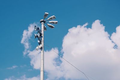 Low angle view of lighting equipment against blue sky