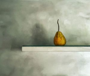Close-up of apple on table against wall