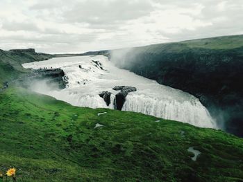 Scenic view of waterfall against sky