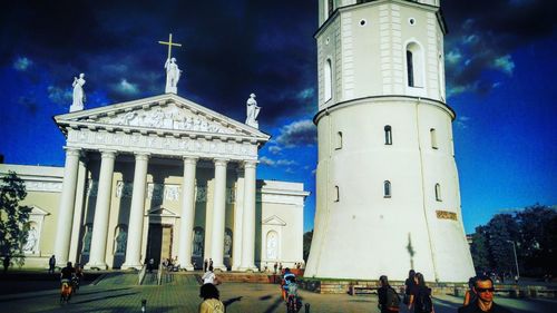 Tourists in front of building against sky