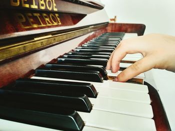 Cropped image of hand playing piano