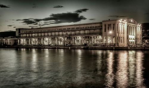 Illuminated buildings against sky at dusk