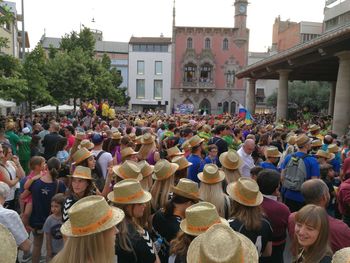 Crowd standing by tree in city