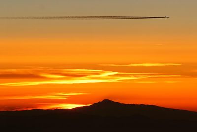 Scenic view of silhouette mountains against romantic sky at sunset