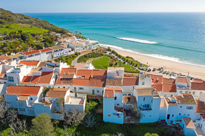 High angle view of townscape by sea against sky