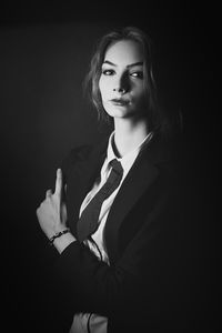 Portrait of beautiful young woman against black background