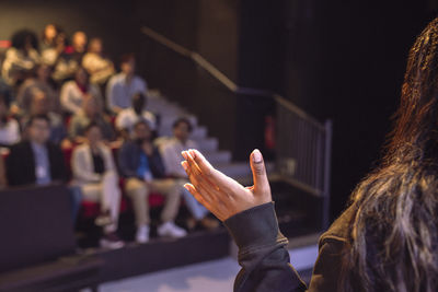 Hand of female speaker gesturing while talking in seminar at theater