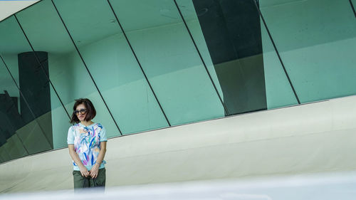 Portrait of smiling woman against wall