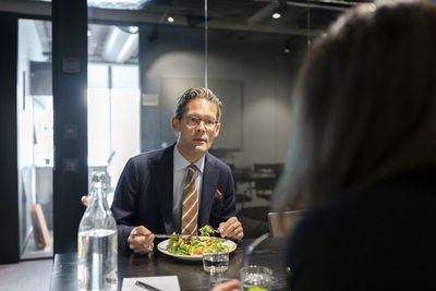 Mature businessman having meal