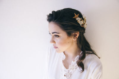 Portrait of young woman looking away against white background