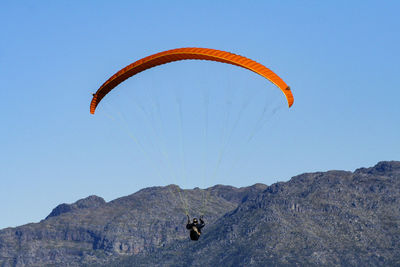 Person paragliding against sky