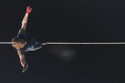 Low angle view of man jumping against clear sky