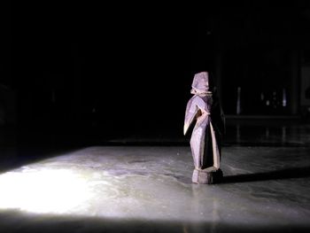 Close-up of figurine on table in illuminated building