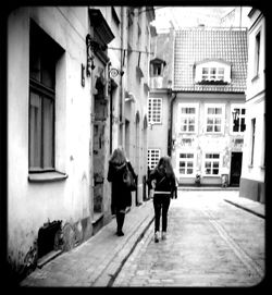 Rear view of man and woman walking in city