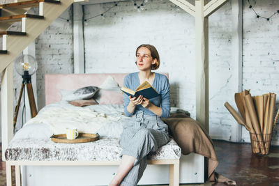 Young woman using phone while sitting on seat