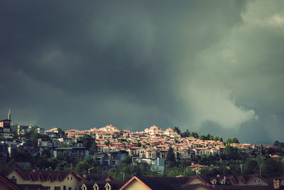 Aerial view of townscape against storm clouds