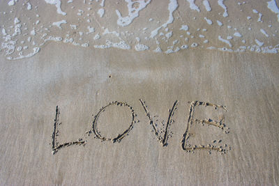 High angle view of text on sand at beach