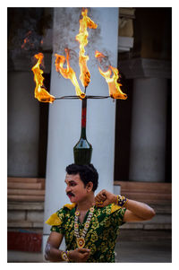 Midsection of man holding burning candles