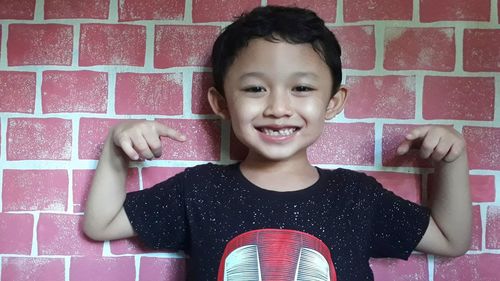 Portrait of smiling boy against wall