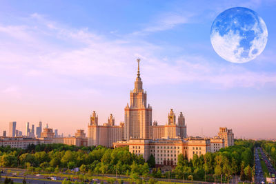 Buildings in city against cloudy sky