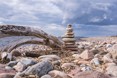 Stack of stones on rock against sky