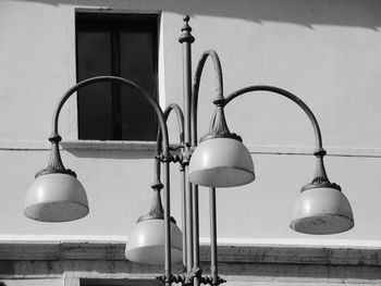 Low angle view of electric lamp against wall