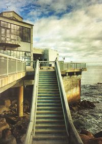 Pier on sea against cloudy sky