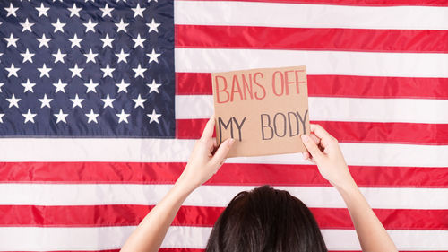 Rear view of woman holding american flag