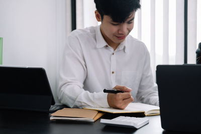 Man using mobile phone while sitting on table