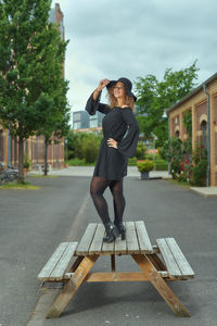 Full length of woman standing on footpath