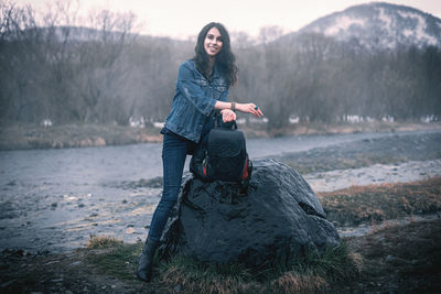 Full length of young woman holding rock