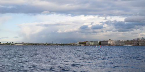 Scenic view of sea by buildings against sky