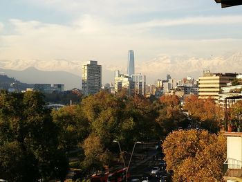 Trees and cityscape against sky