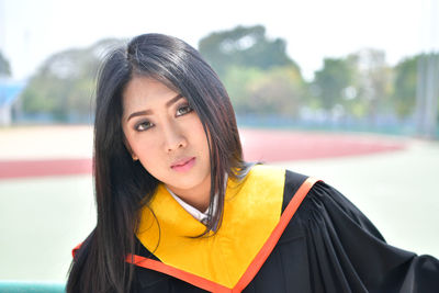 Portrait of beautiful young woman in graduation gown