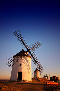 Low angle view of traditional windmill on field against clear sky