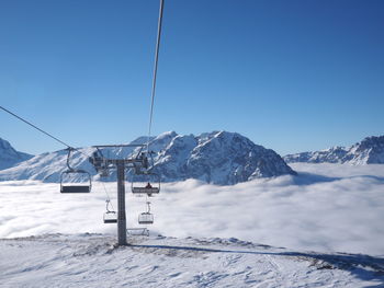 Snow covered mountain range against blue sky