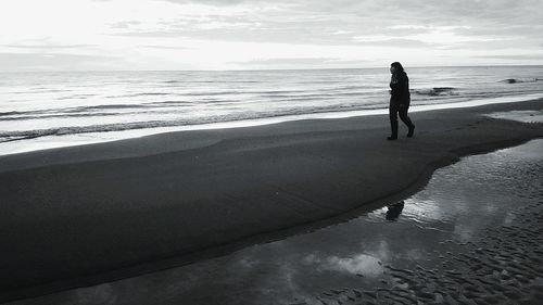 Silhouette people walking on beach