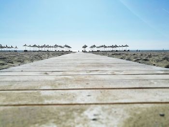 Surface level of footpath by sea against clear sky