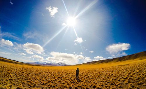 Full length of man standing on desert against sky during sunny day