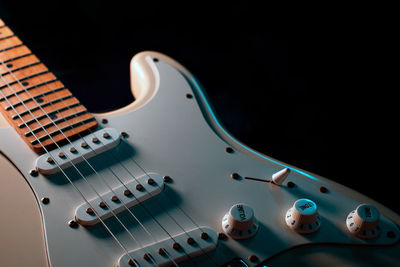 Close-up of guitar against black background