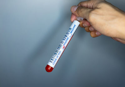 Close-up of hand holding hands over white background