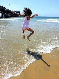 Full length of girl jumping at beach