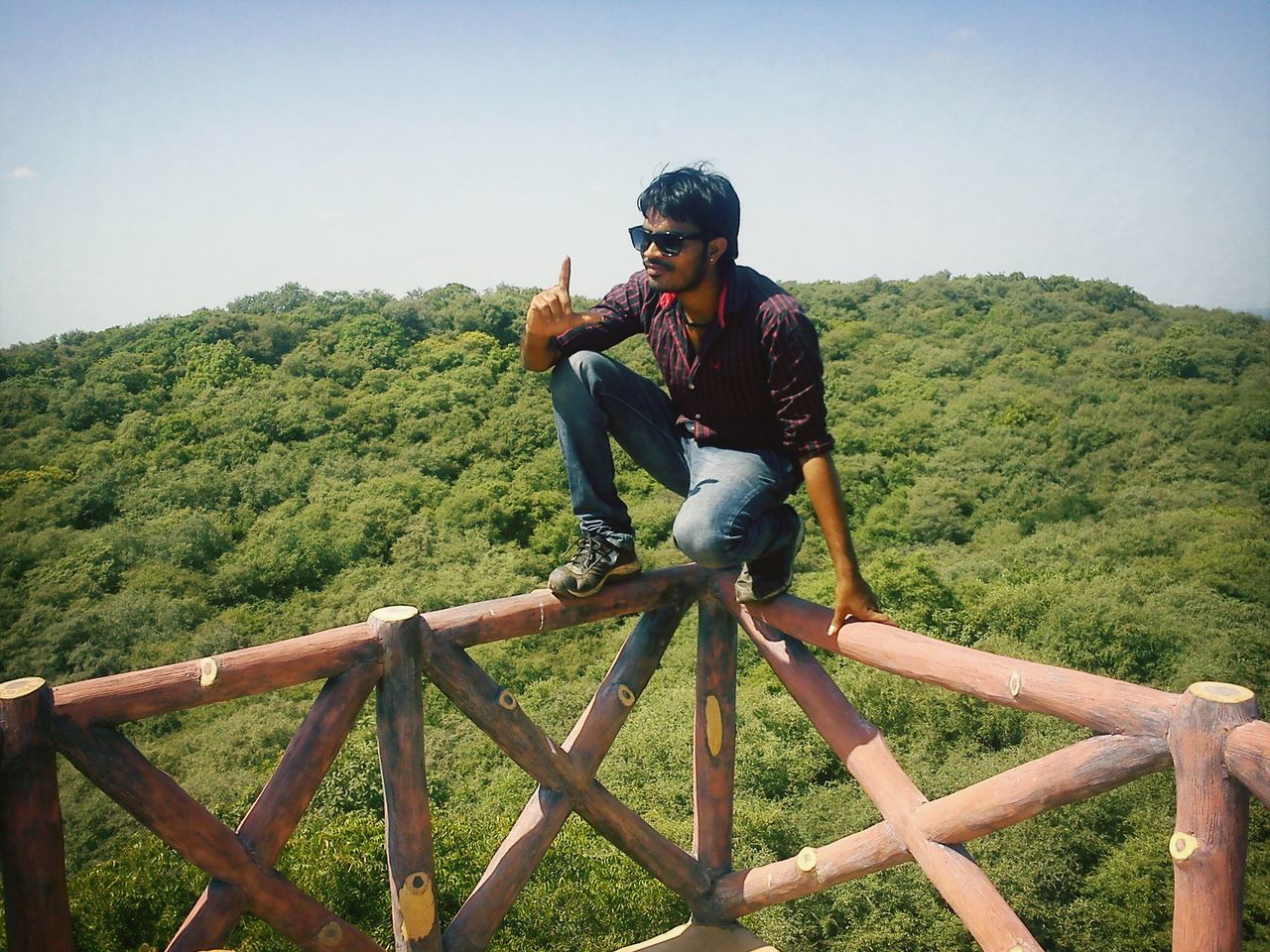 leisure activity, lifestyles, casual clothing, railing, full length, mountain, young adult, person, clear sky, standing, sky, tree, nature, young men, landscape, day, outdoors, travel