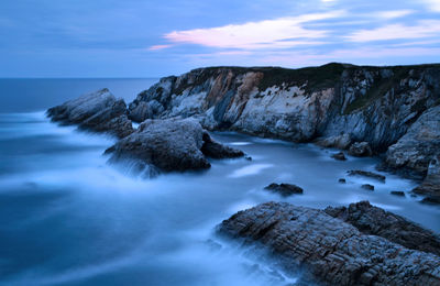 Rocks in sea against sky